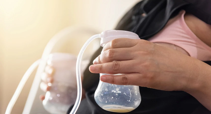 A mother pumping milk into a bottle.